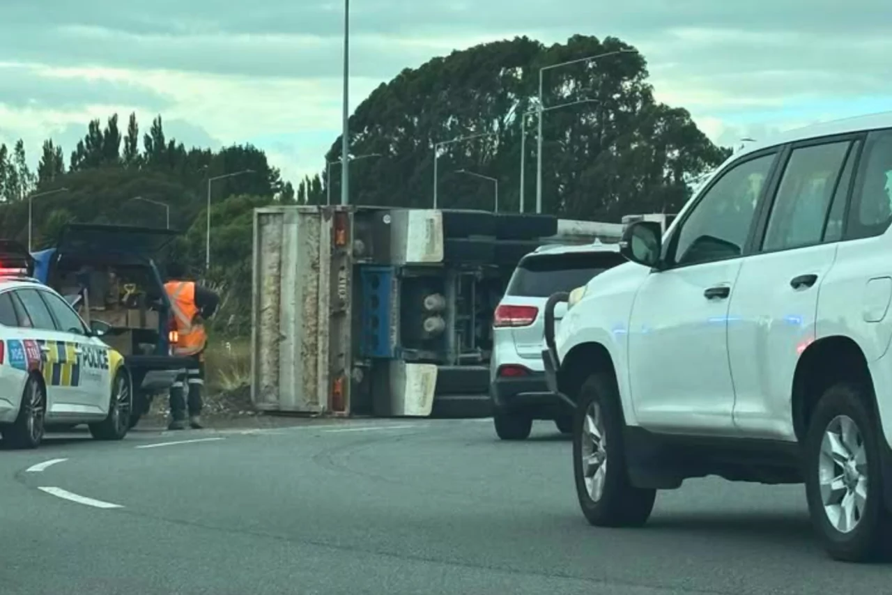 Truck and trailer rollover leaves driver injured on QEII Drive